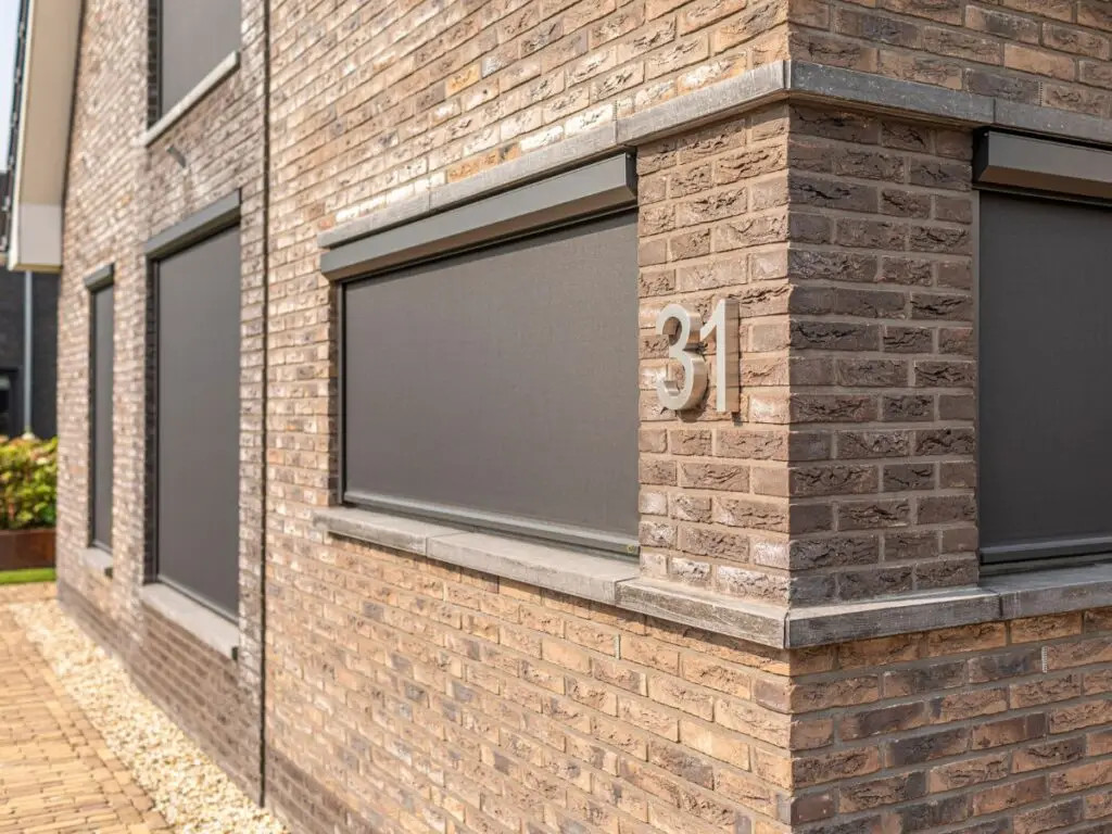 Aanzicht van een woning, voorzien van screens op de beneden- en bovenverdieping.