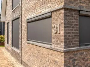 Aanzicht van een woning, voorzien van screens op de beneden- en bovenverdieping.